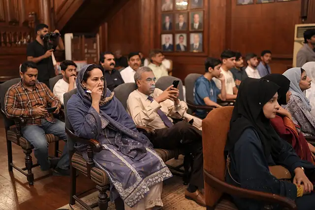 Audience members listening to an address