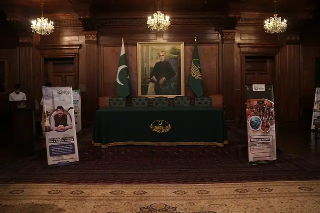The ceremony stage with a green-draped table, flags and NSDP standees