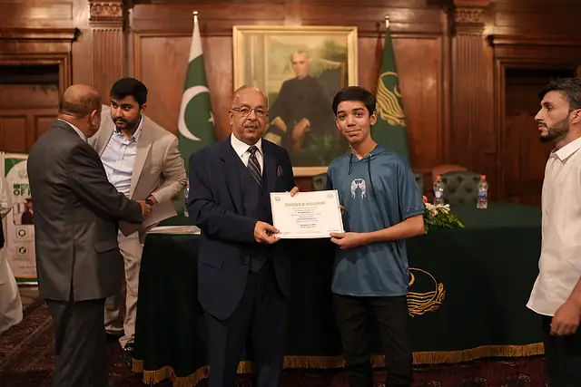 Major General Zawar Hussain Shah (Retd) presents a certificate to a young student