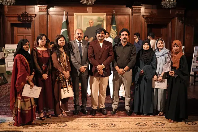 Women students pose for a group photo with guests
