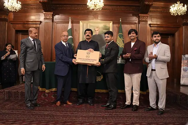 The Governor of Punjab presents a laptop box to a student