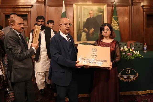 Major General Zawar Hussain Shah (Retd) presents a laptop box to a student