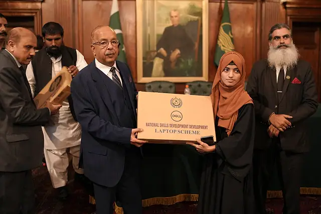 Major General Zawar Hussain Shah (Retd) presents a laptop box to a student in a hijab