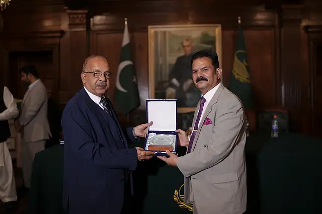 Major General Zawar Hussain Shah (Retd) presents a shield to a guest